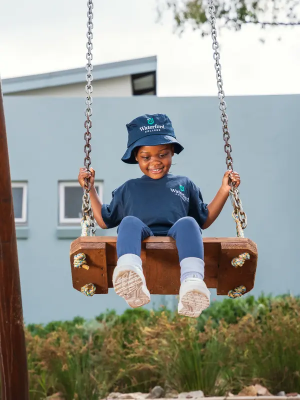 A child on a swing in the school grounds