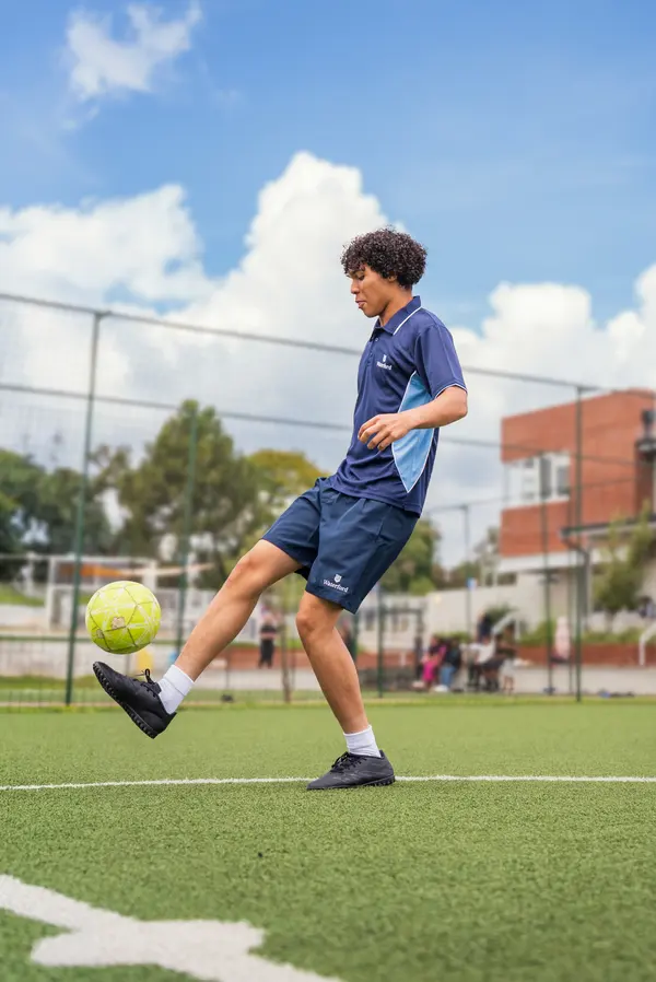 A student kicking a soccer ball