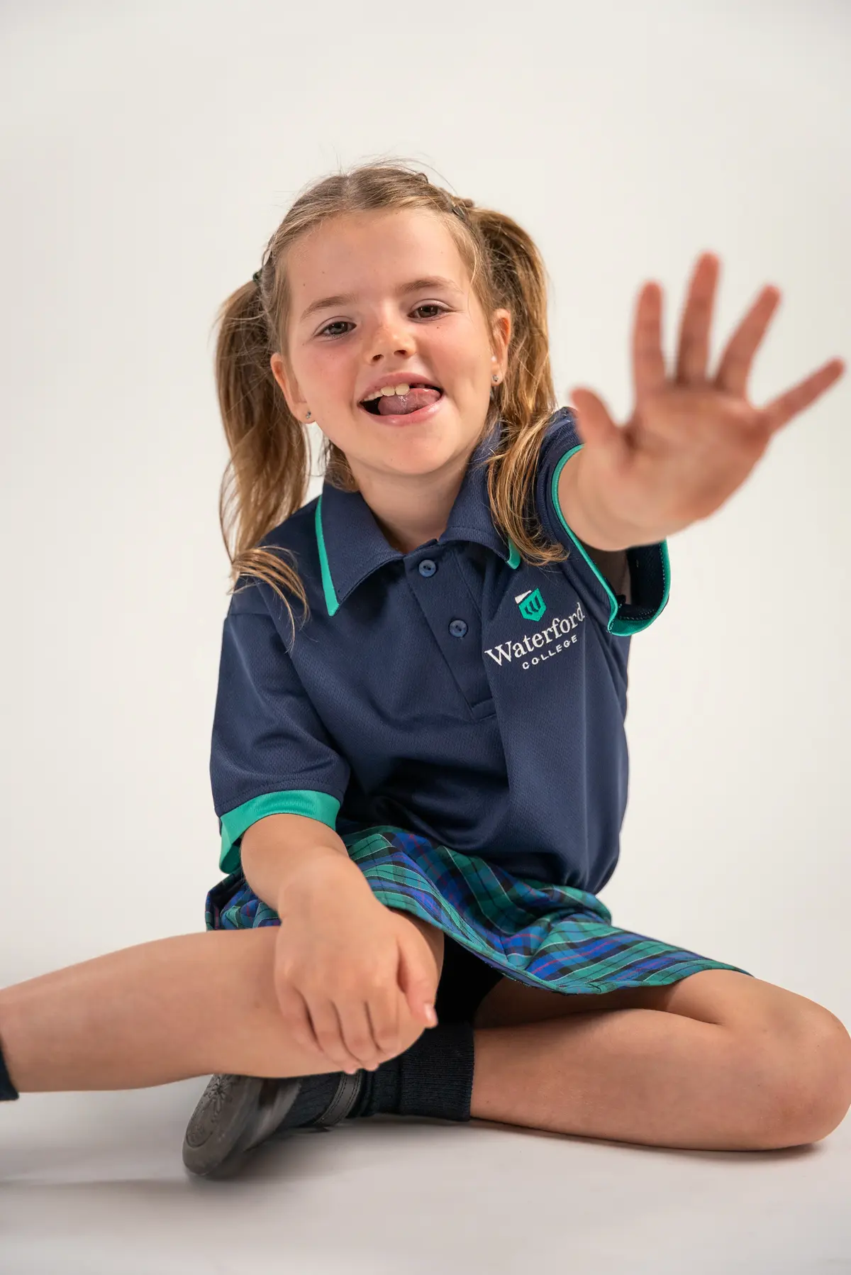 A child reaching towards the camera and smiling