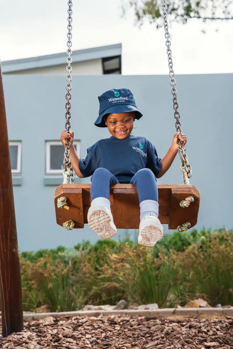 A child on a swing in the school grounds