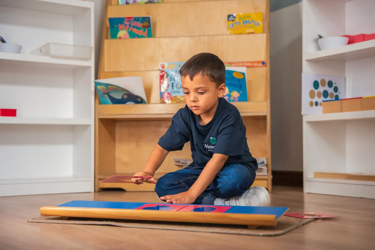 A child absorbed in a floor activity in a prepared classroom